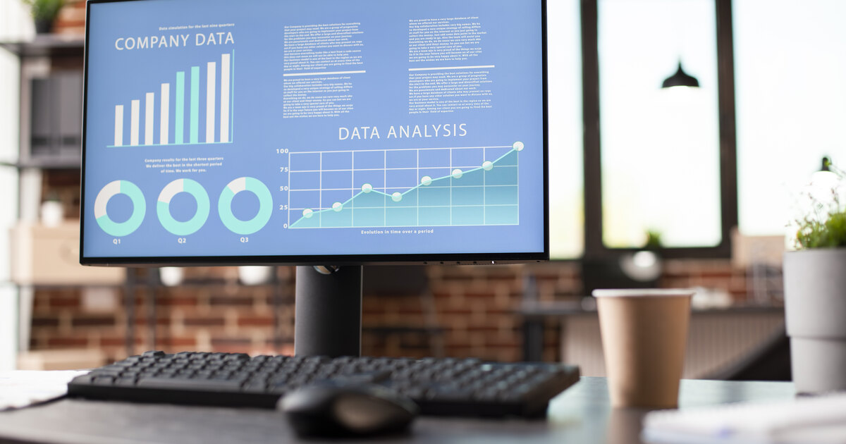 Office monitor displaying conversion analytics with bar chart and data-analysis trend line