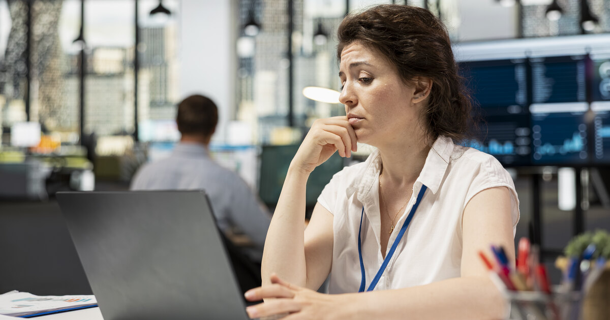 Analyst with a puzzled expression reviewing conversion test results on a laptop in an office